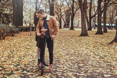 Güz parkında scooter sürmek