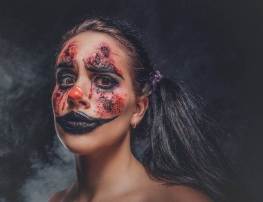 Karanlık fotoğraf stüdyosundaki şeytani palyaço portresi.