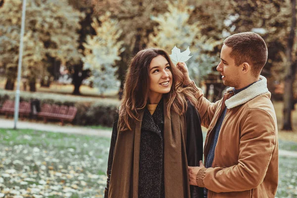 Pareja romántica divertirse con hoja de otoño — Foto de Stock