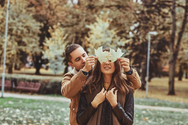 Pareja romántica divertirse con hoja de otoño — Foto de Stock