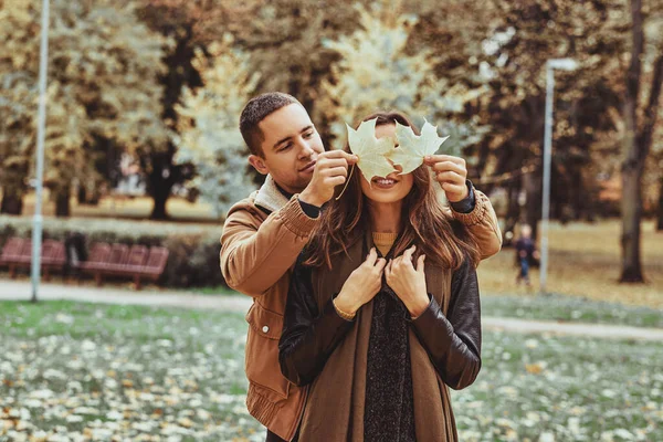 Pareja romántica divertirse con hoja de otoño — Foto de Stock