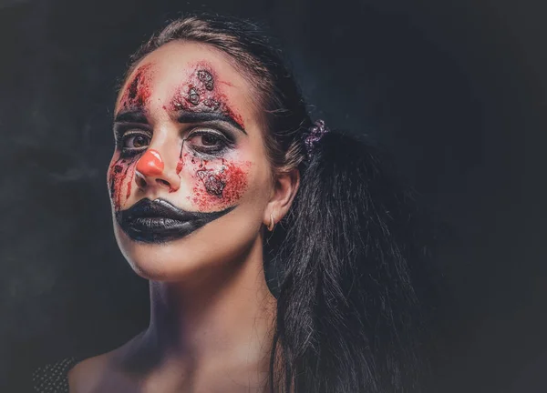 Portret van kwaadaardige griezelige clown in donkere fotostudio — Stockfoto