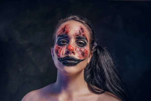 Portret van kwaadaardige griezelige clown in donkere fotostudio — Stockfoto