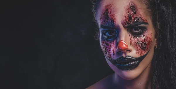 Ung kvinna spelar en roll som ond clown — Stockfoto