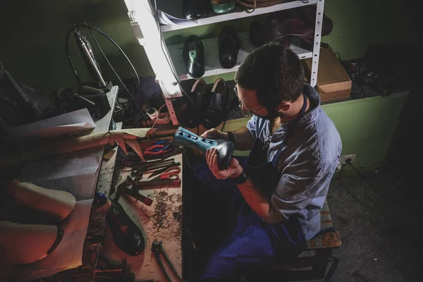 Cobbler reparerar skor åt kunder — Stockfoto