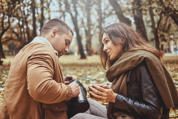 Paar trinkt Tee im Herbstpark — Stockfoto