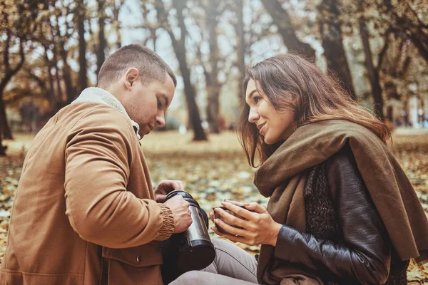 Pareja está bebiendo té en el parque de otoño — Foto de Stock