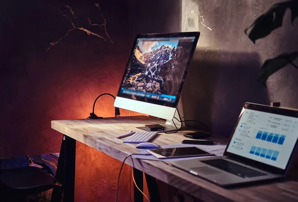 Table with computer and laptop on it — ストック写真