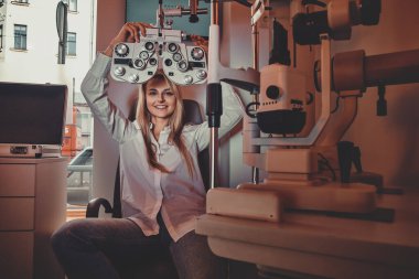 Kadın gözlükçü dolabını kontrol ediyor.