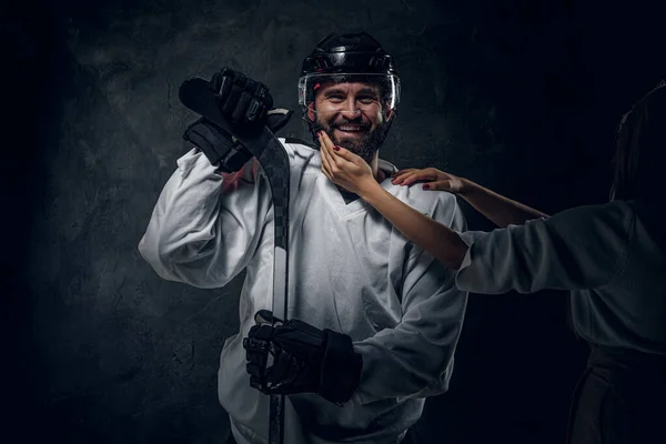 Портрет брутального хоккеиста с женской рукой — стоковое фото