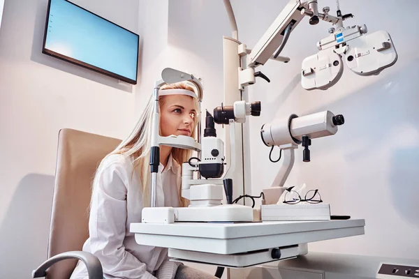 Vrouw controleert haar zicht bij opticien kabinet — Stockfoto
