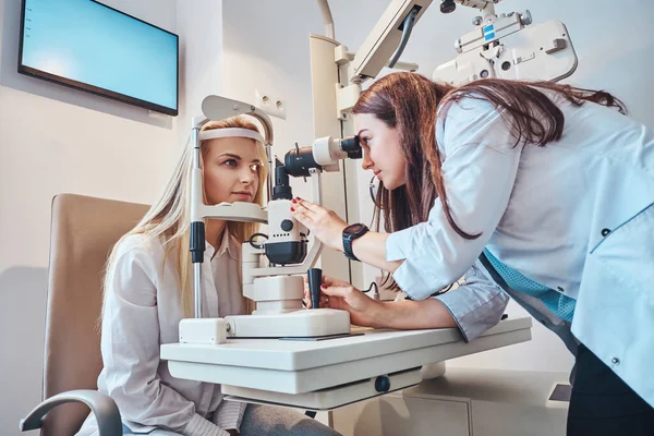 Vrouw controleert haar zicht bij opticien kabinet — Stockfoto