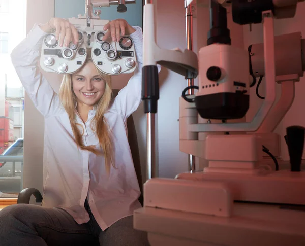 Mulher está verificando sua visão no armário óptico — Fotografia de Stock