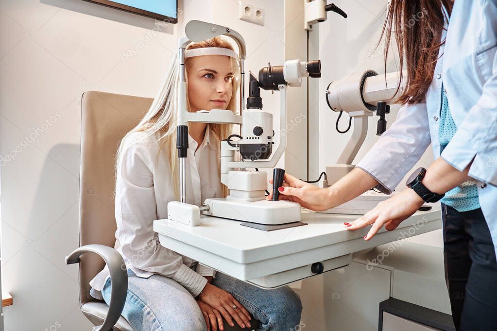 Woman Is checking her sight at optician cabinet