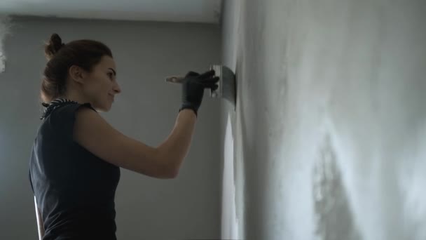 Mulher está pintando parede a cor cinza — Vídeo de Stock