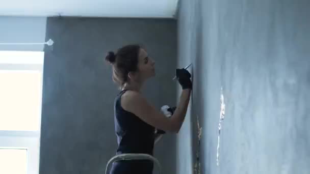 La mujer está pintando en la pared gris — Vídeos de Stock