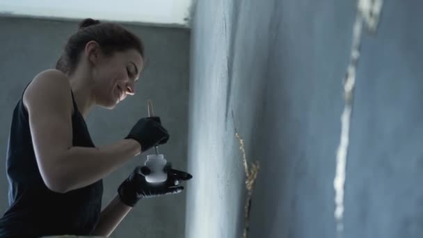 La mujer está pintando en la pared gris — Vídeos de Stock