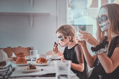 Çocuklar evde şekerle eğleniyor.