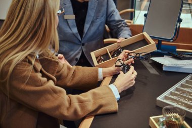 Hanımefendi dükkanda yeni gözlük seçiyor.