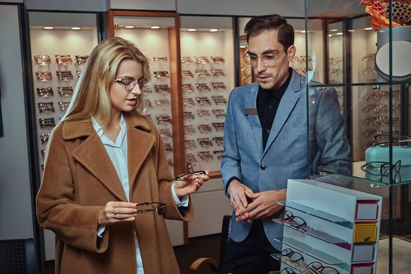 Mulher está escolhendo novos quadros para óculos — Fotografia de Stock