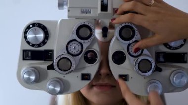 Göz doktoru hastaların gözlerini kontrol ediyor.