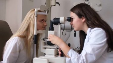 Göz doktoru hastaların gözlerini kontrol ediyor.