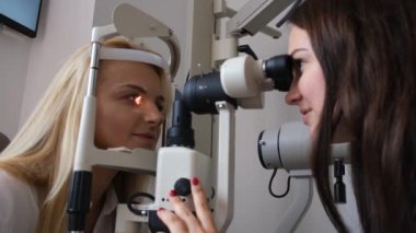 Göz doktoru hastaların gözlerini kontrol ediyor.