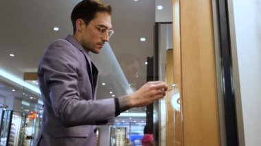 Optik mağazasının danışmanı gözlüğü temizliyor.