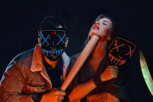 Portrait of crazy couple in masks with bat — Stock Photo, Image