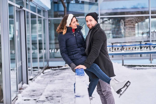 Junges verliebtes Paar küsst sich auf Eisbahn — Stockfoto
