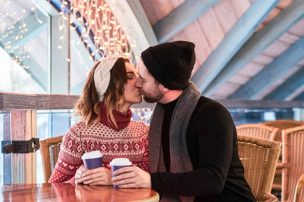 크리스마스 때 카페에서 대화하고 키스하는 젊은 커플 — 스톡 사진