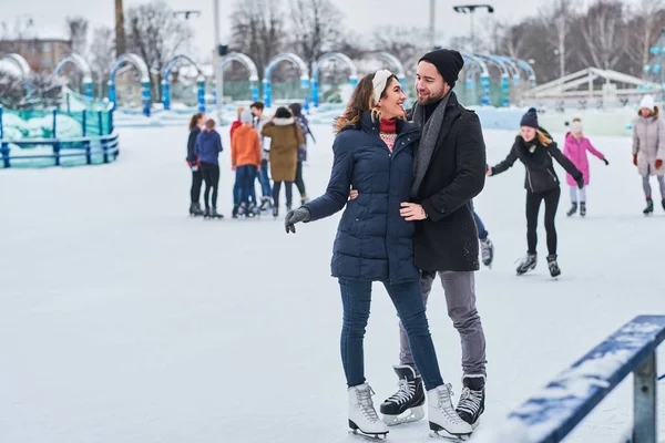 Glückliches Paar beim Dating in der Eishalle, beim Umarmen und im Winter — Stockfoto