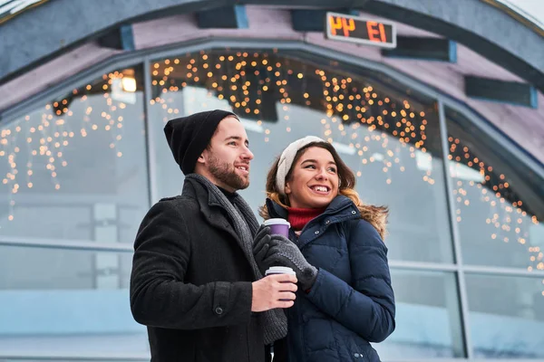 Pareja joven en una cita cerca de la pista de hielo — Foto de Stock