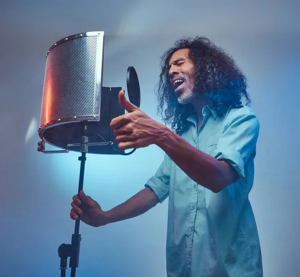 Afrikaanse zangeres draagt een blauw hemd emotioneel schrijvend lied in de opnamestudio. — Stockfoto