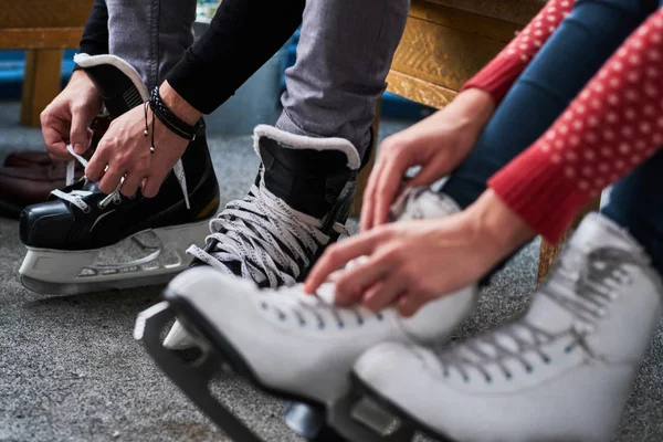 Jovem casal se preparando para uma patinação — Fotografia de Stock