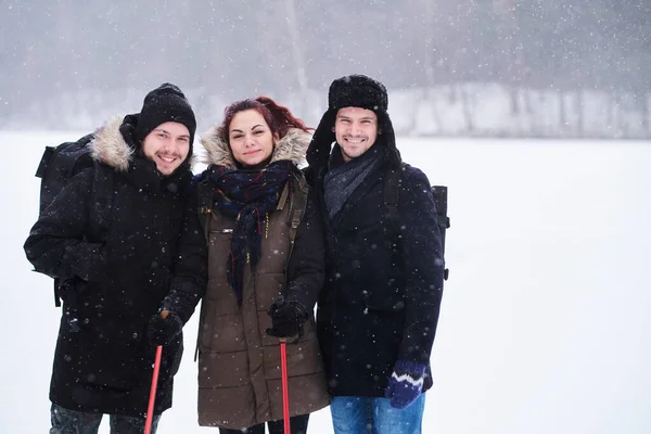 Amigos caminham no frio floresta nevada ficar em um abraço e olhar para a câmera . — Fotografia de Stock