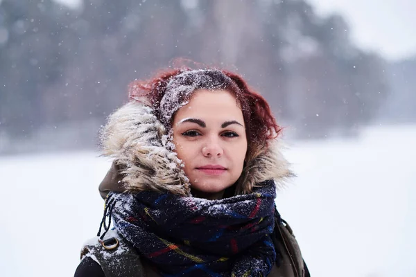 Porträt eines rothaarigen Mädchens in warmer Kleidung im verschneiten Wald — Stockfoto