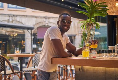 Adam kafeye meyve suyu döküyor.