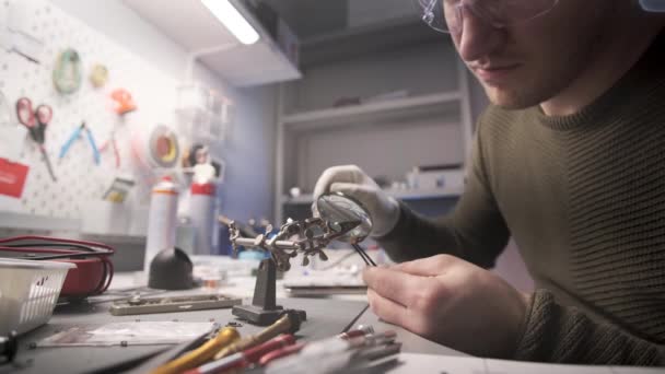 Electronics repairman repairs smartphone in service center. — Stock Video