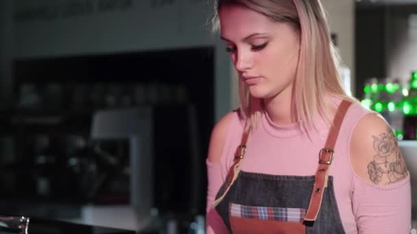 Hermosa joven vendedor de paquetes de pasteles de pie en el mostrador en la confitería — Vídeos de Stock