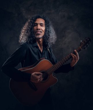 Akustik gitarlı çekici orta yaşlı bir adamın portresi.