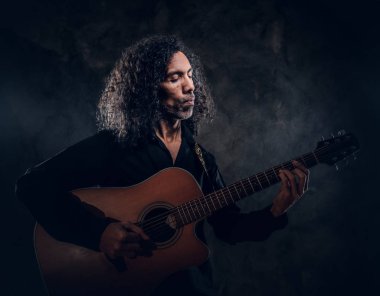 Akustik gitarlı çekici orta yaşlı bir adamın portresi.