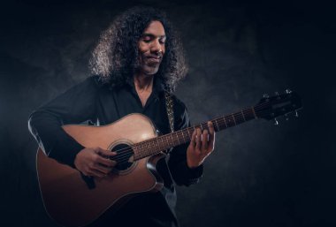 Akustik gitarlı çekici orta yaşlı bir adamın portresi.