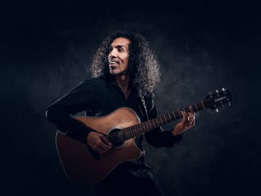 Akustik gitarlı çekici orta yaşlı bir adamın portresi.