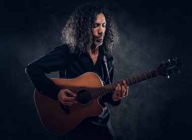 Akustik gitarlı çekici orta yaşlı bir adamın portresi.