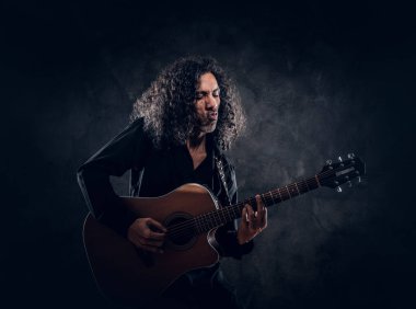Akustik gitarlı çekici orta yaşlı bir adamın portresi.