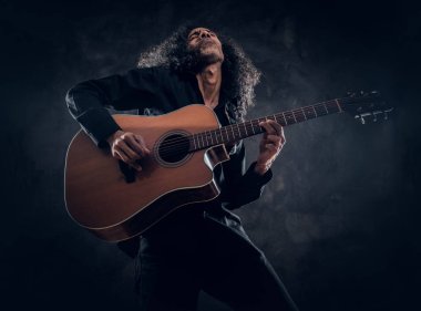 Akustik gitarlı çekici orta yaşlı bir adamın portresi.