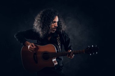 Akustik gitarlı çekici orta yaşlı bir adamın portresi.