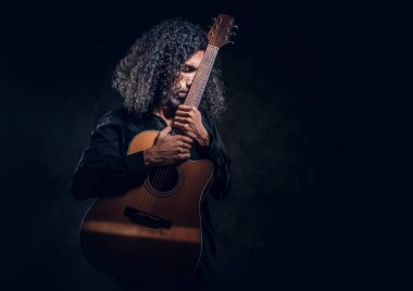 Akustik gitarlı çekici orta yaşlı bir adamın portresi.