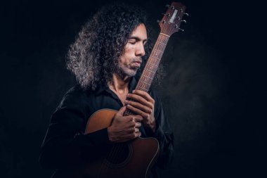 Akustik gitarlı çekici orta yaşlı bir adamın portresi.